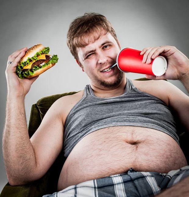 gordo sentado tomando coca cola e comendo um hamburger